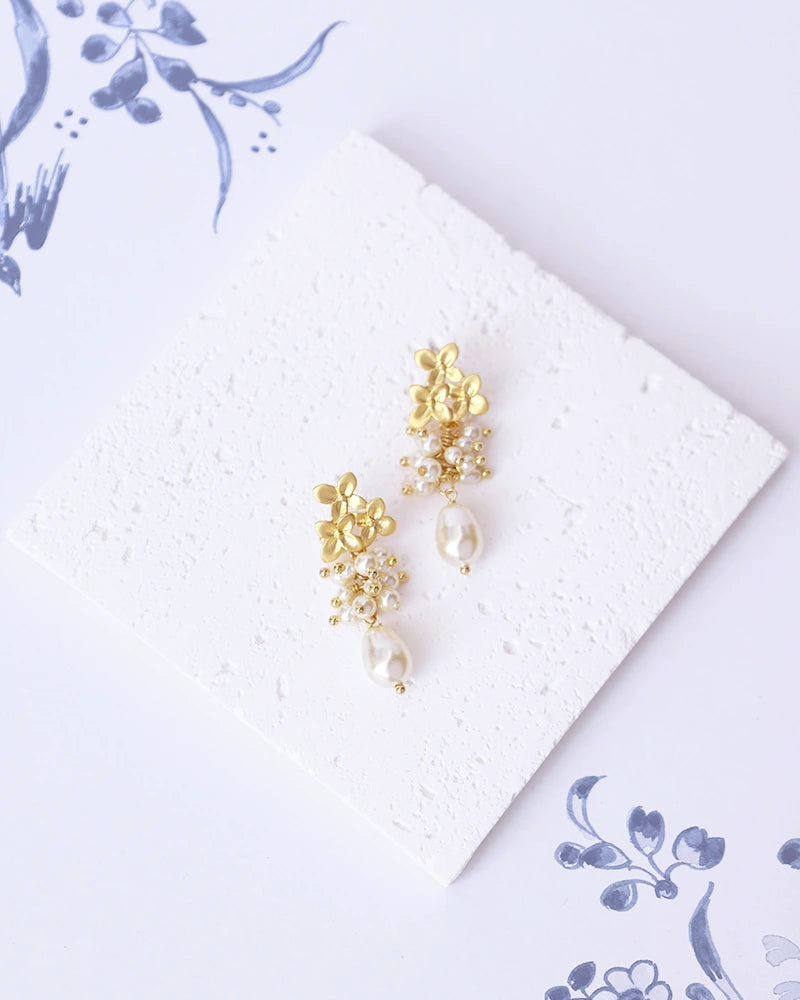 Boucles d’oreilles de mariée Éléa avec perles et fleurs de myosotis, création Atelier Sarah Aime.